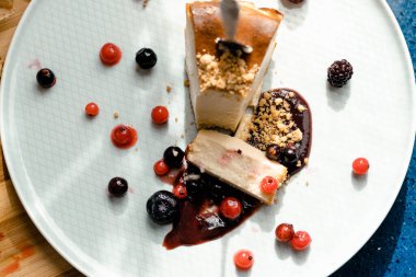 Ev yapımı cheesecake porsiyonu ve böğürtlen manzarası. Yakın plan.