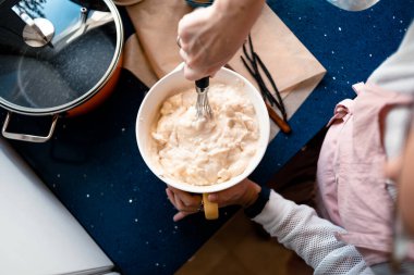 Cheesecake 'in malzemelerini kaseye karıştıran bir kadının görüntüsü.