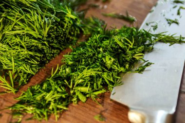 Tahta üzerinde bahçeden yeşil dereotu bir bıçakla kesilmiş