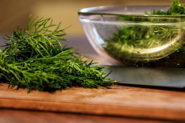 Tahta üzerinde bahçeden yeşil dereotu bir bıçakla kesilmiş