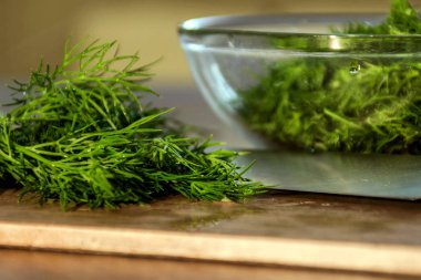 Tahta üzerinde bahçeden yeşil dereotu bir bıçakla kesilmiş