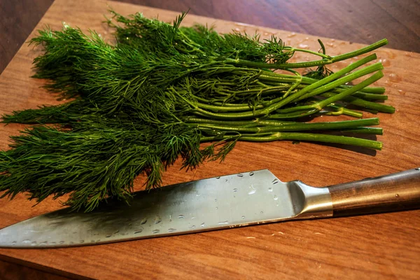 green dill from the garden on the Board cut with a knife