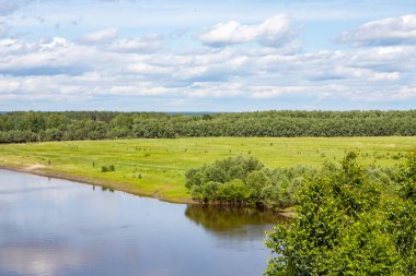 Ağaçların mavi gökyüzüne karşı yansımasıyla ormanın etrafında küçük bir nehir akar. Sibirya 'nın doğası böyle..