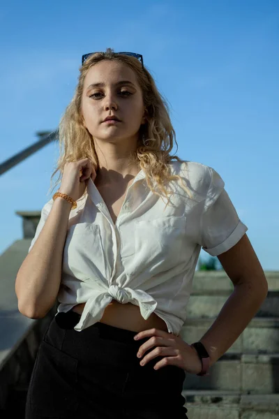 Een Jong Meisje Een Wit Shirt Houdt Haar Blonde Haar — Stockfoto