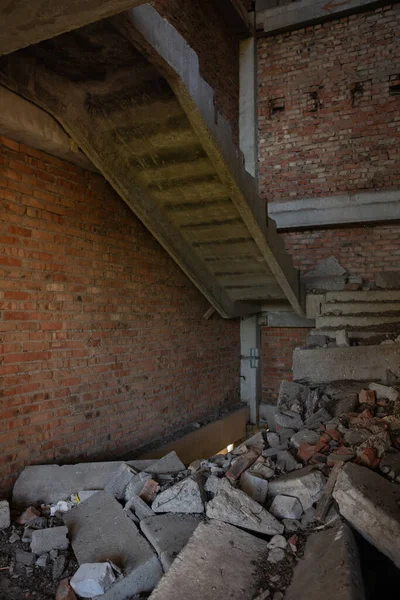 A ruined, crumbling staircase in an abandoned building. A flight of stairs collapsed in the entrance of an unfinished house