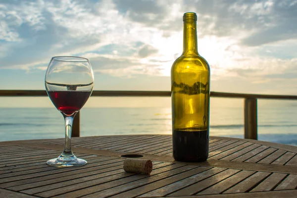 wine glass with bottle of wine and beautiful sunset