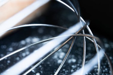 Gümüş mutfak el mikseri siyah masanın üzerinde. Yanında un ve hamur silindiri var..