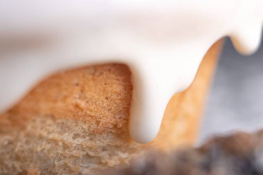 Nefis taze pişmiş tarçınlı rulo beyaz kremayla kaplı ve önünde bir parça tarçın var..