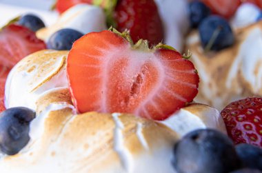 Enfes ev yapımı kırmızı meyveli pasta, üstünde çilek ve krema var..