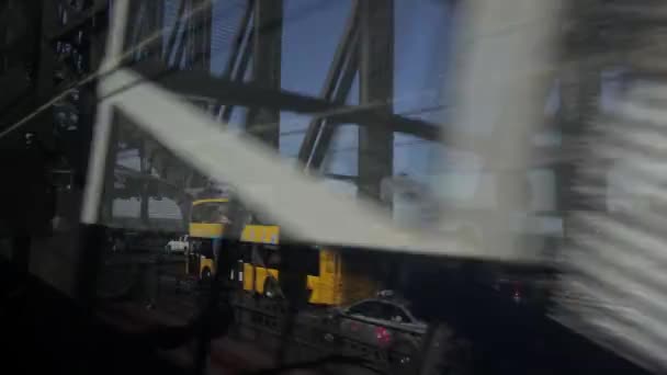 Sydney, Australië - 17 oktober 2019: Verkeer op Sydney Harbour Bridge vanaf de trein op een zonnige doordeweekse middag met blauwe hemel en gele bus — Stockvideo