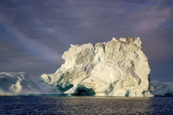 Ogromne pływające lodowce w morzu oświetlone promieniami słońca — Zdjęcie stockowe