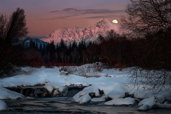 Krivan escudo con la luna en su totalidad sobre un río de montaña —  Fotos de Stock