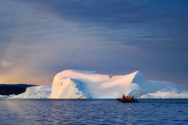 Turistas ou cientistas no mar com icebergs ao pôr do sol na noite polar — Fotografia de Stock