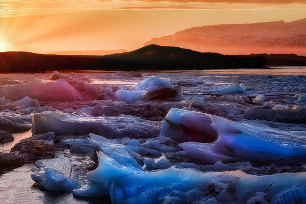 Ηλιοβασίλεμα σε παγωμένη λιμνοθάλασσα κάτω από το παγόβουνο — Φωτογραφία Αρχείου