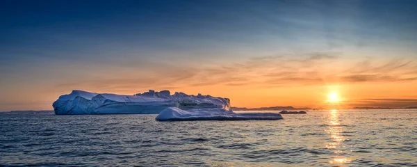 Glaciares flotantes en los rayos del sol poniente en la noche polar — Foto de Stock