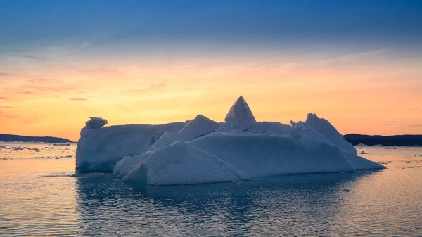 Glaciares flotantes en los rayos del sol poniente en la noche polar —  Fotos de Stock