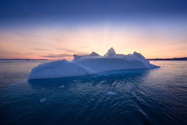 floating glaciers in the rays of the setting sun at polar night clipart