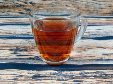 Masada taze demlenmiş bir fincan siyah çay var. 