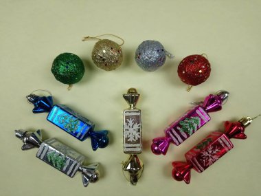 Masada dört renkli Noel topu ve beş tatlı var.