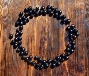 Siyah frenk üzümü masanın üzerinde bir daire şeklinde duruyor.