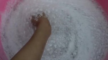 Bir insan suyu eliyle karıştırır ve kabarcıklar üretir.