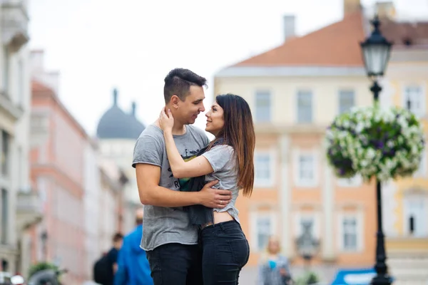 Şehrin arka planında poz veren genç çift, seyahat kavramı — Stok fotoğraf