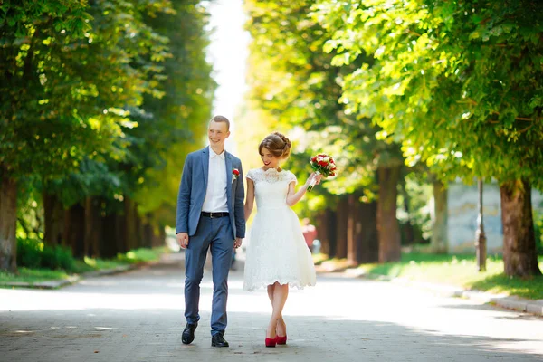 결혼식 날 신부와 신랑을 데리고 자연스럽게 야외에서 걷는 모습. — 스톡 사진