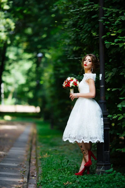 Elegante Braut und Bräutigam posieren zusammen im Freien an einem Hochzeitstag — Stockfoto