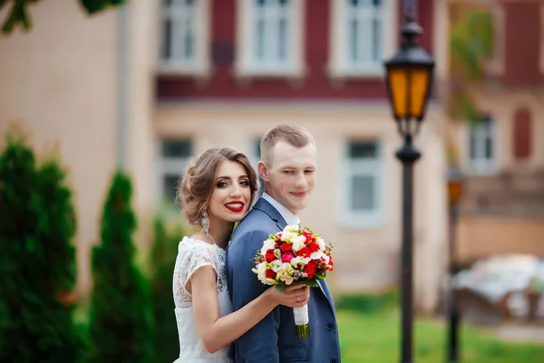 Fabelhaftes junges Hochzeitspaar posiert an einem sonnigen Tag im Park. — Stockfoto