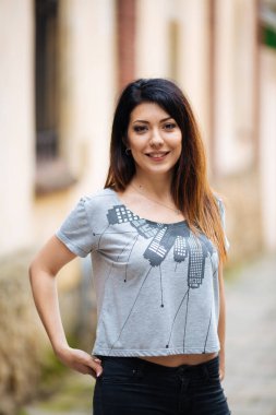 Duvarın yanında kot pantolonlu güzel kız.