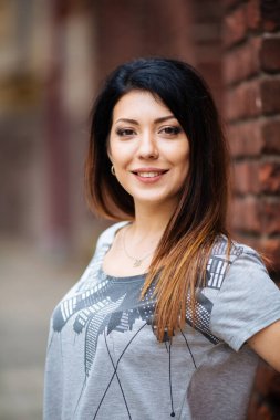 Duvarın yanında kot pantolonlu güzel kız.