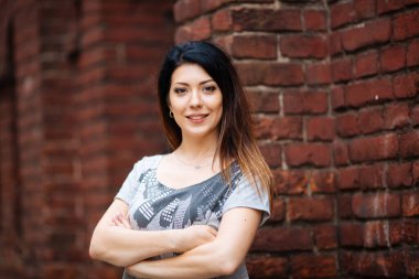 Duvarın yanında kot pantolonlu güzel kız.