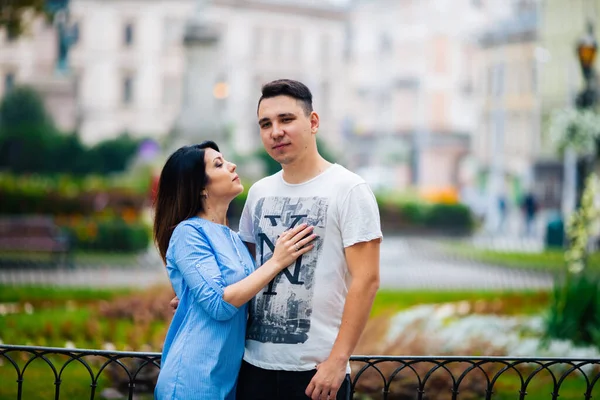 Şehrin arka planında poz veren genç çift, seyahat kavramı — Stok fotoğraf