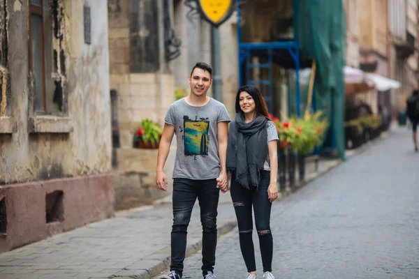 Ένα ερωτευμένο ζευγάρι περπατά αργά στους δρόμους της πόλης ένα δροσερό πρωινό του φθινοπώρου. — Φωτογραφία Αρχείου
