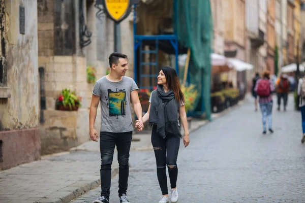 Şehrin arka planında poz veren genç çift, seyahat kavramı — Stok fotoğraf