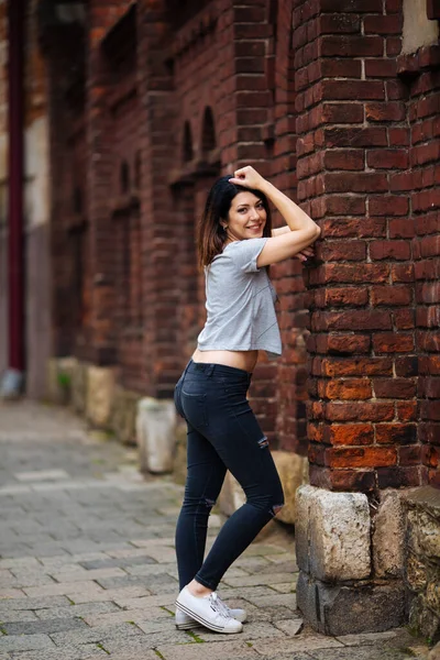 Piękna dziewczyna przy ścianie w dżinsach — Zdjęcie stockowe