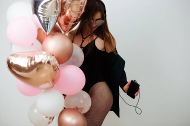 Stüdyoda renkli toplarla eğlenen esmer kadın.