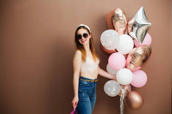 Meisje met rode ballonnen lacht, geïsoleerd op de achtergrond. — Stockfoto