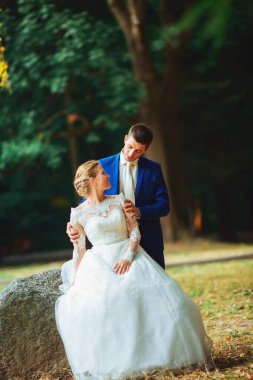 Romantik bir an. Lüks gelinlik içinde güzel bir gelin ve smokinli şık bir gelin.