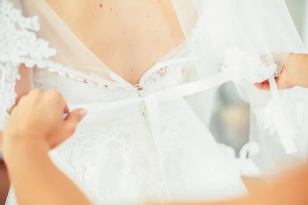 Menina em um vestido branco em casa. Noiva com maquilhagem. Casamento. Preparando a noiva para o próximo casamento . — Fotografia de Stock