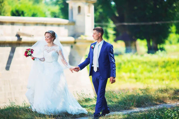 Coppia nuziale, sposa in abito da sposa bianco e sposo passeggiando nel bosco, ballando e sorridendo — Foto Stock