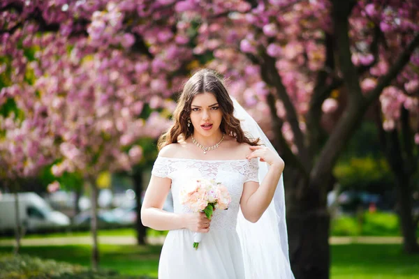 Braut posiert in der Nähe von Sakura in Paris. Hochzeit — Stockfoto