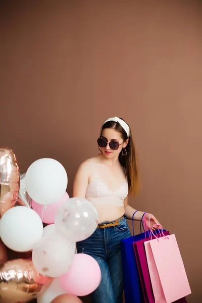 Wakacje i koncepcja mody - szczęśliwa młoda kobieta lub nastolatka z balonami helowymi i zakupami — Zdjęcie stockowe