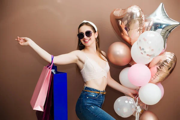 Vakantie en mode concept - gelukkige jonge vrouw of tienermeisje met helium ballonnen en winkelen — Stockfoto