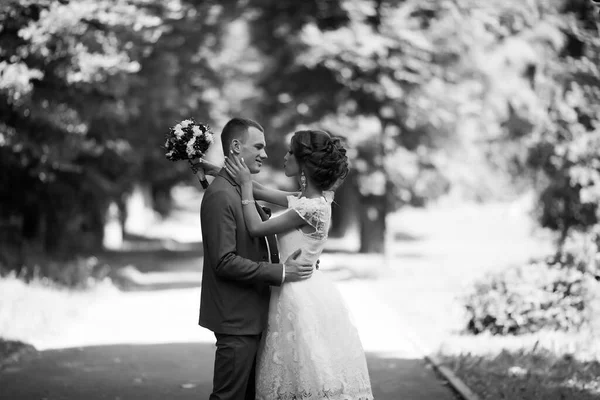 Glückliche Braut und Bräutigam bei ihrer Hochzeit. Frischvermählte im Park. — Stockfoto