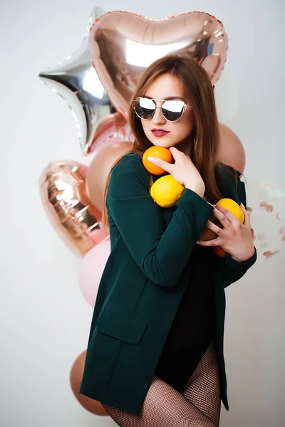 Souriant brune heureuse femme à la mode tenant des ballons posant. Plan studio. — Photo