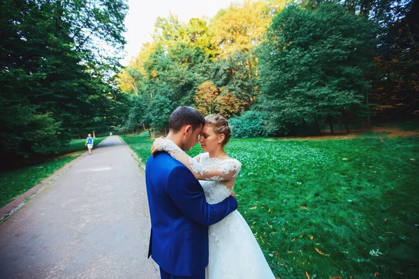 Coppia nuziale, sposa in abito da sposa bianco e sposo passeggiando nel bosco, ballando e sorridendo — Foto Stock