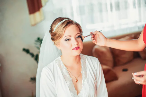 Professionelle Maskenbildnerin arbeitet mit junger Braut zu Hause — Stockfoto