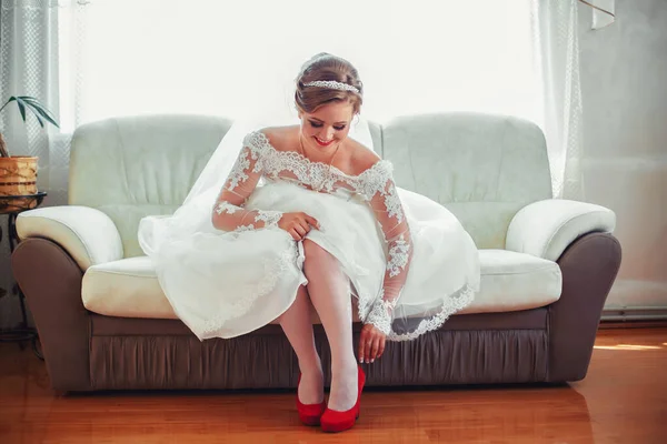 Menina em um vestido branco em casa. Noiva com maquilhagem. Casamento. Preparando a noiva para o próximo casamento . — Fotografia de Stock