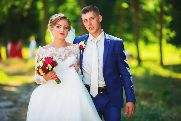 Romantischer Moment. Schöne Braut im luxuriösen Brautkleid und stilvolle Braut im Smoking — Stockfoto